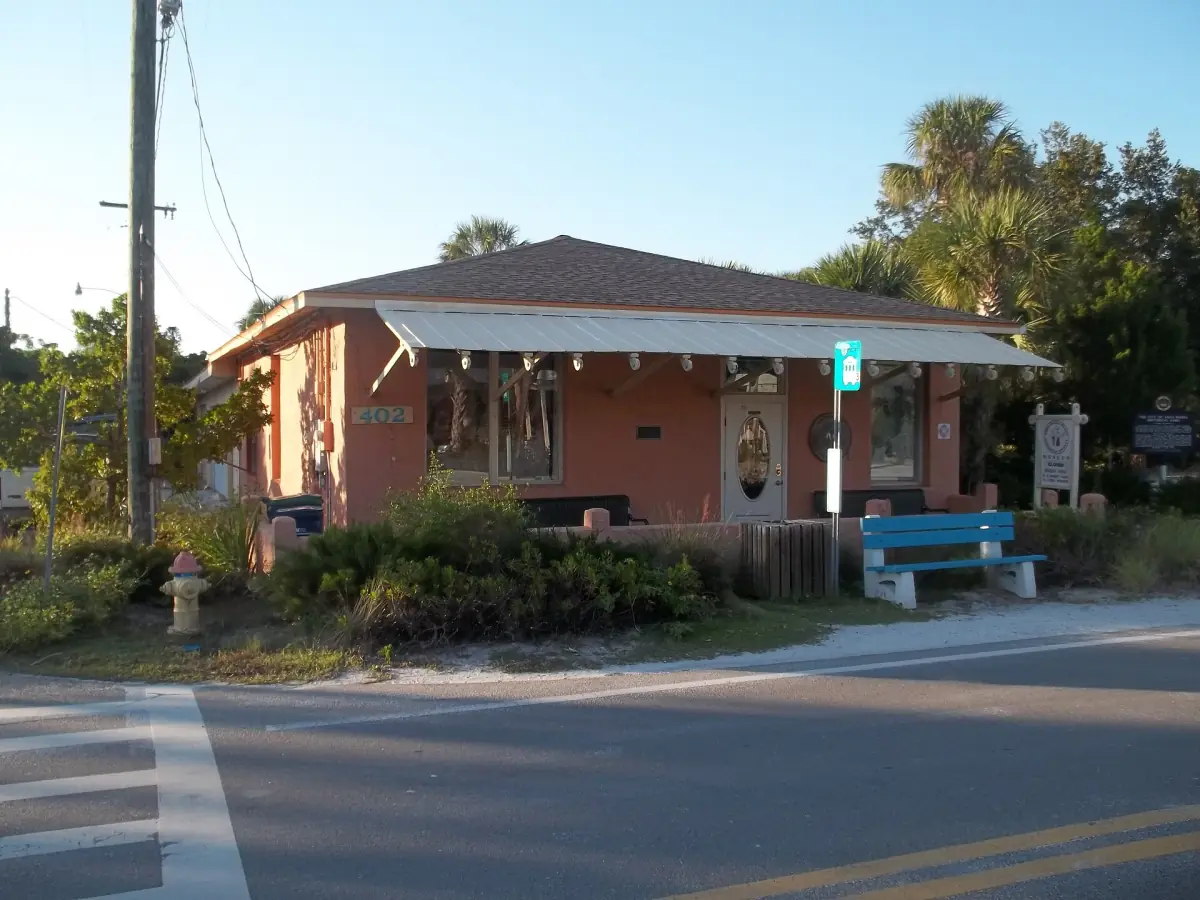 Small historic museum building with a tiled roof beside a quiet street
