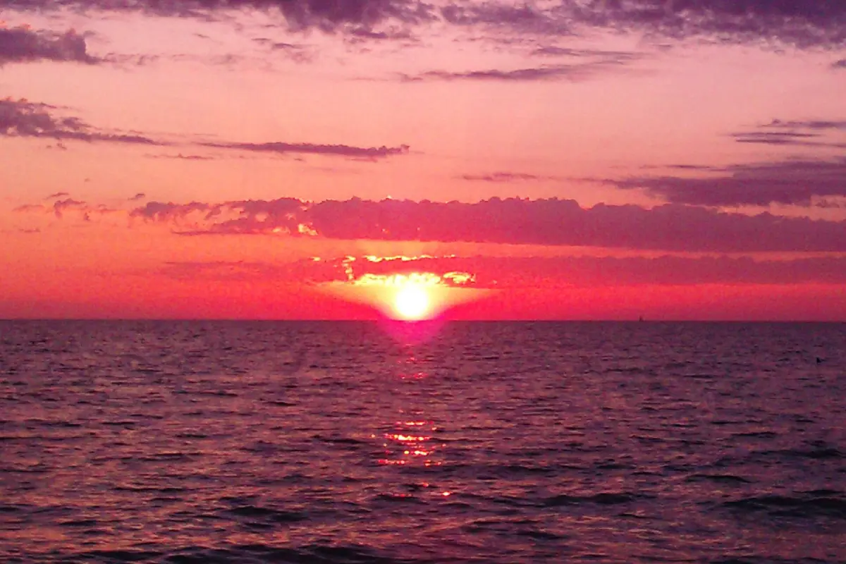 Red sun setting over the Gulf at Holmes Beach