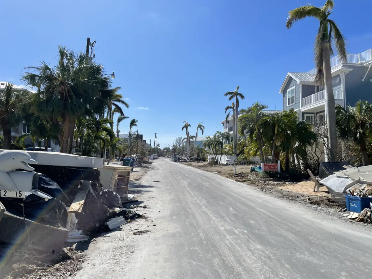 Street lined with storm debris after flooding in Holmes Beach
