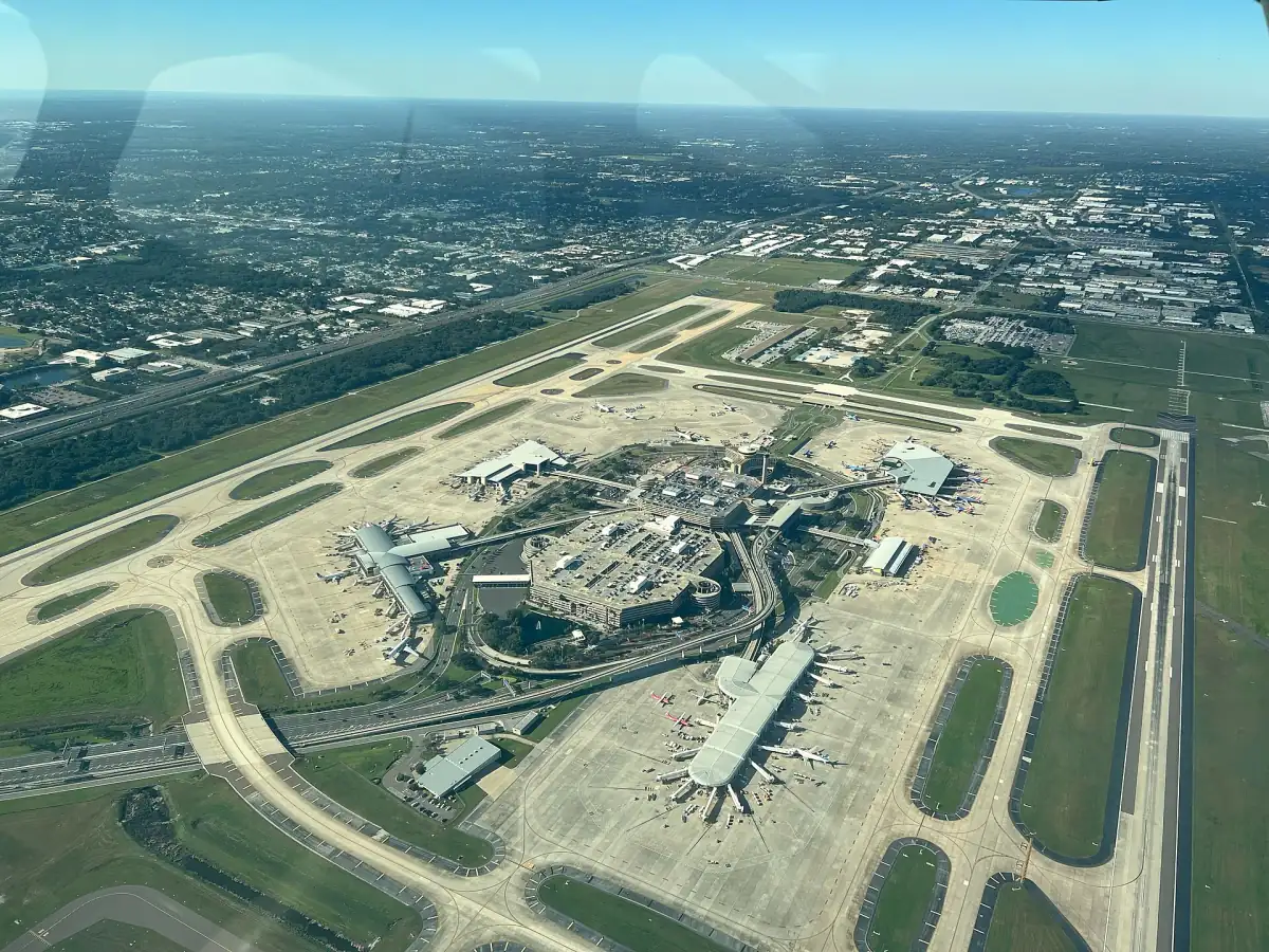 Aerial view of an airport terminal complex with runways and green land